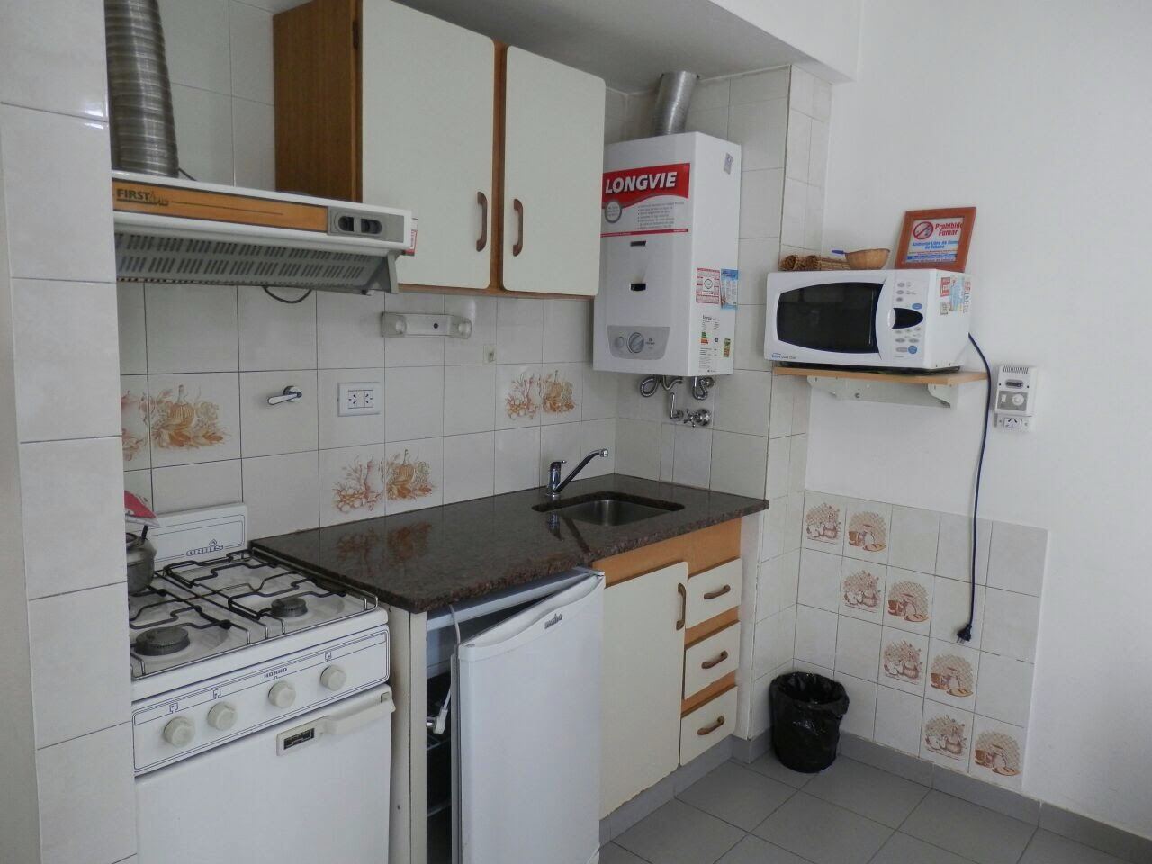 Cocina con horno, heladera, microondas y calef&oacute;n