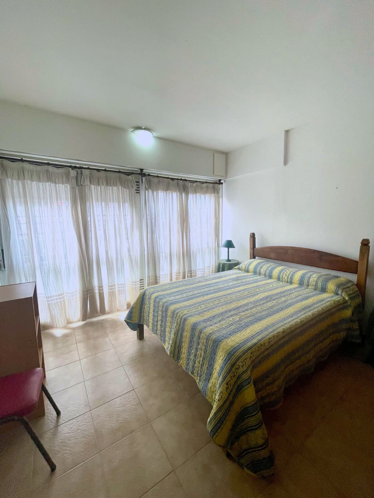 Dormitorio con cama matrimonial y ventanal