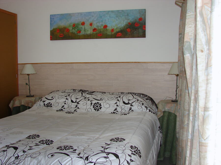 Dormitorio con cama matrimonial y mesas de luz